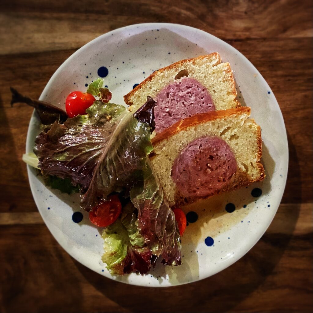 Saucisson brioché, pistache, salade, jus